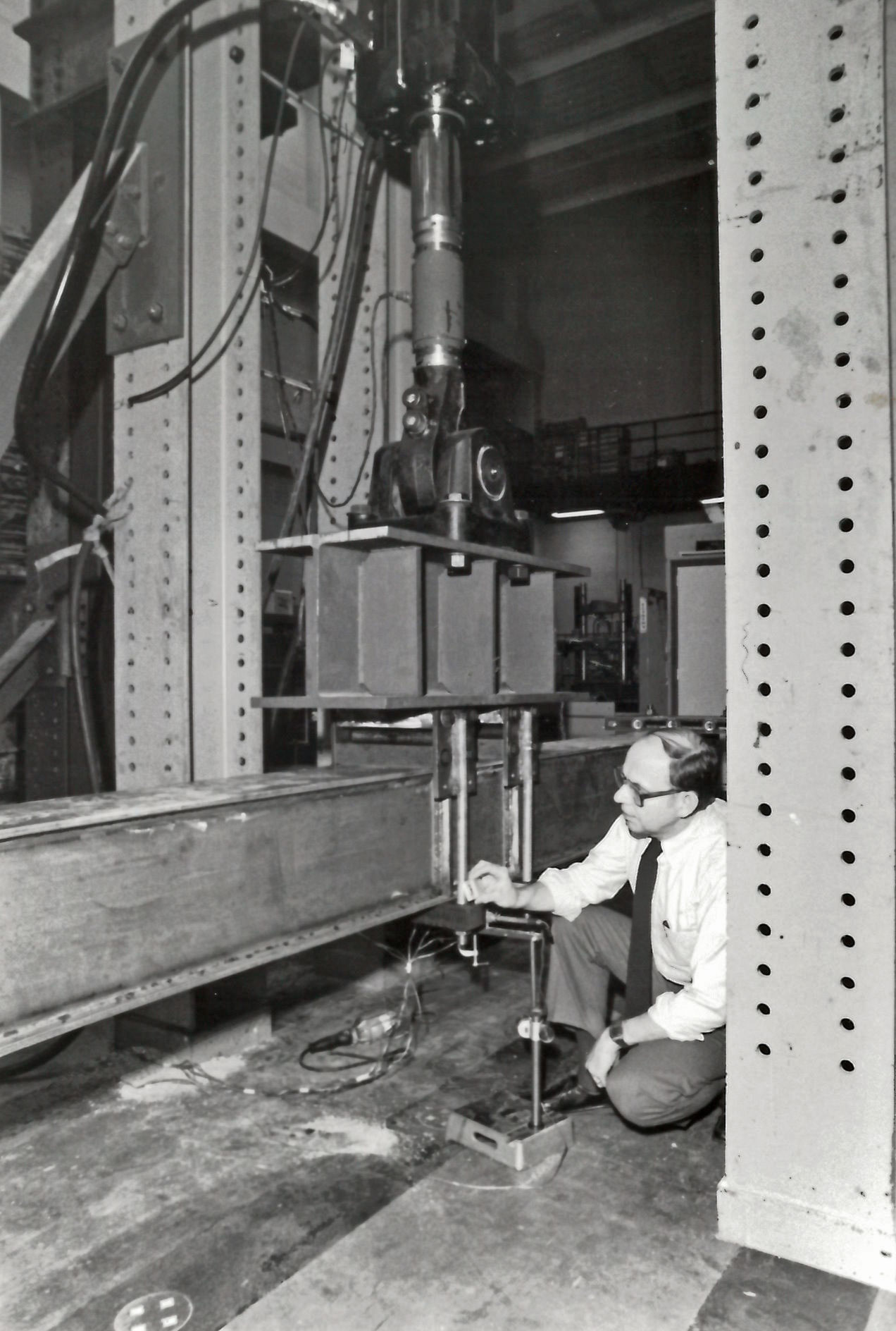 Professor W. H. Walker inspects a welded detail on a beam fatigue specimen, 1986