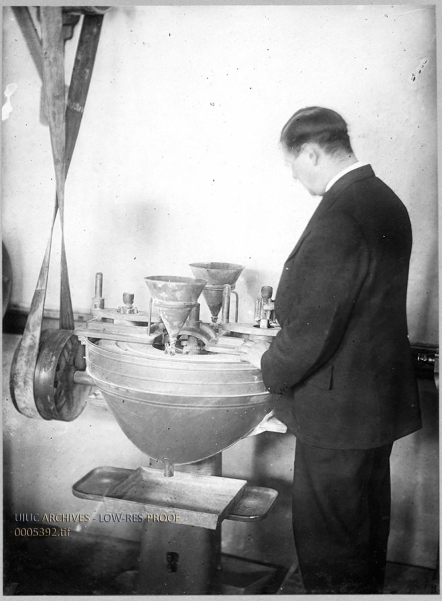 Unidentified Man Testing Stone for Hardness in a Dorry Abrasion Machine